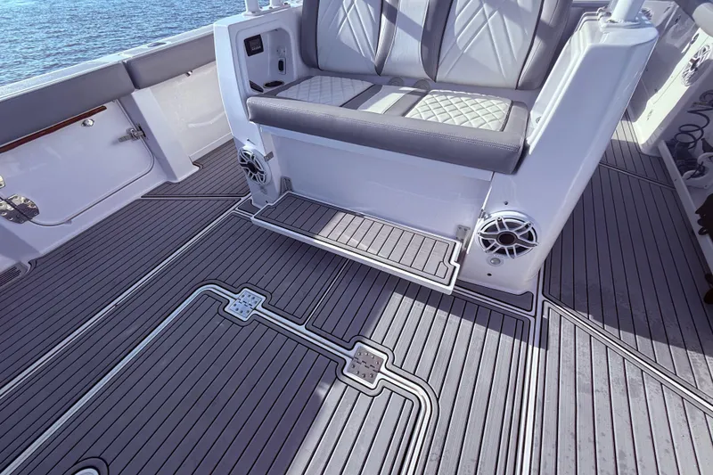 Slide: The Image of 2023 Everglades 395 Center Console boat interior with cushioned seating and sleek flooring design. - 46