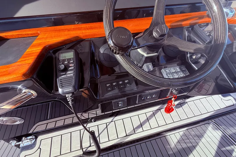 Slide: The Image of 2023 Everglades 395 Center Console dashboard with steering wheel and Garmin radio. - 51