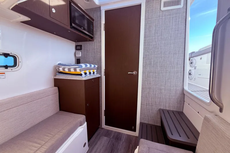 Slide: The Image of Interior of 2023 Everglades 395 Center Console boat with seating, storage, and window view. - 55