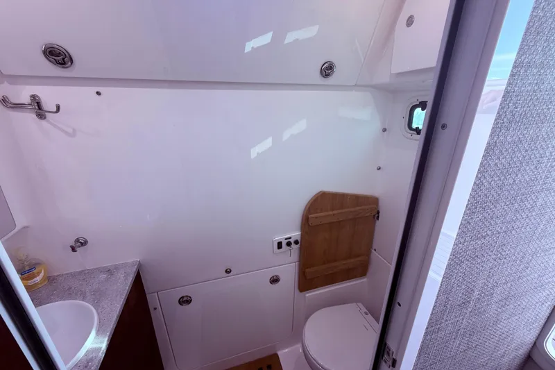 Slide: The Image of 2023 Everglades 395 Center Console boat bathroom interior with sink and toilet. - 57