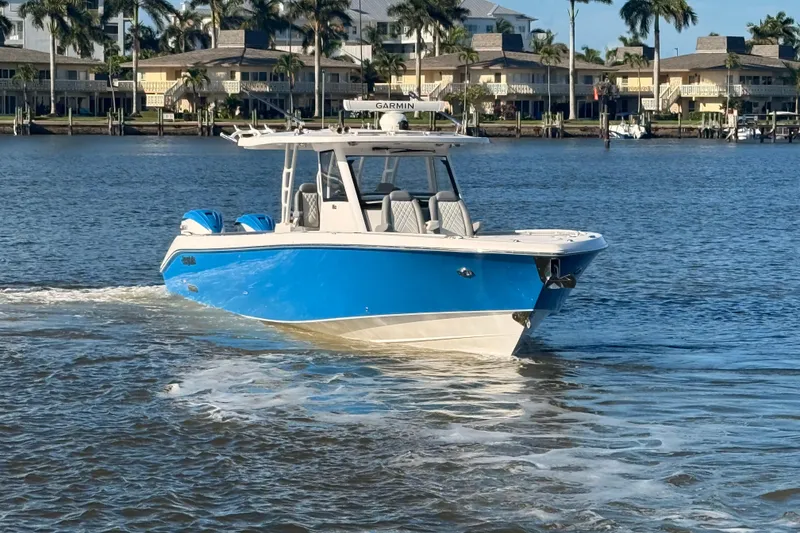 Slide: The Image of 2023 Everglades 395 Center Console boat cruising on a sunny waterfront. - 6