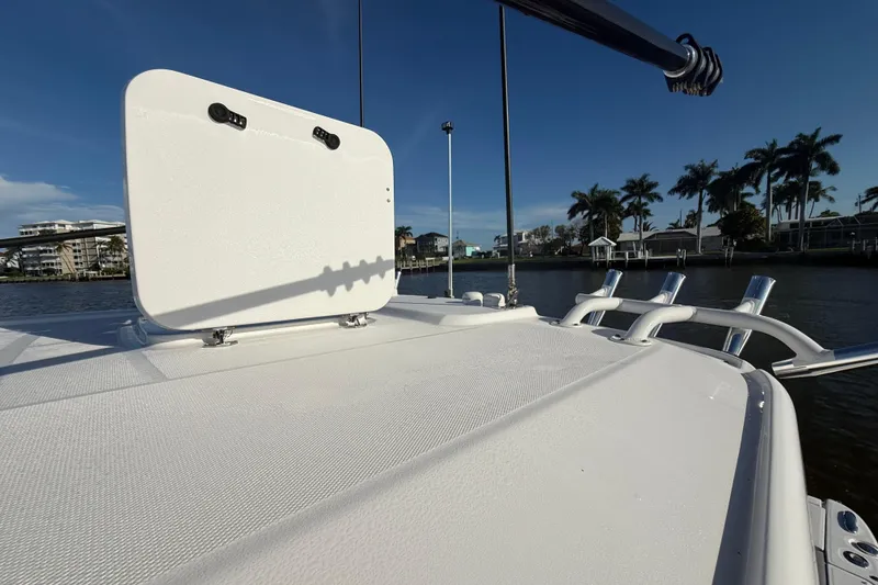 Slide: The Image of 2023 Everglades 395 Center Console boat deck with rod holders, under clear blue sky. - 63