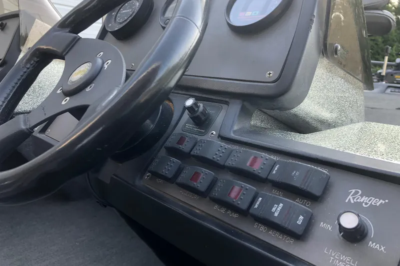 Slide: The Image of Dashboard of a 1993 Ranger Comanche 482v boat with steering wheel and control panel. - 11