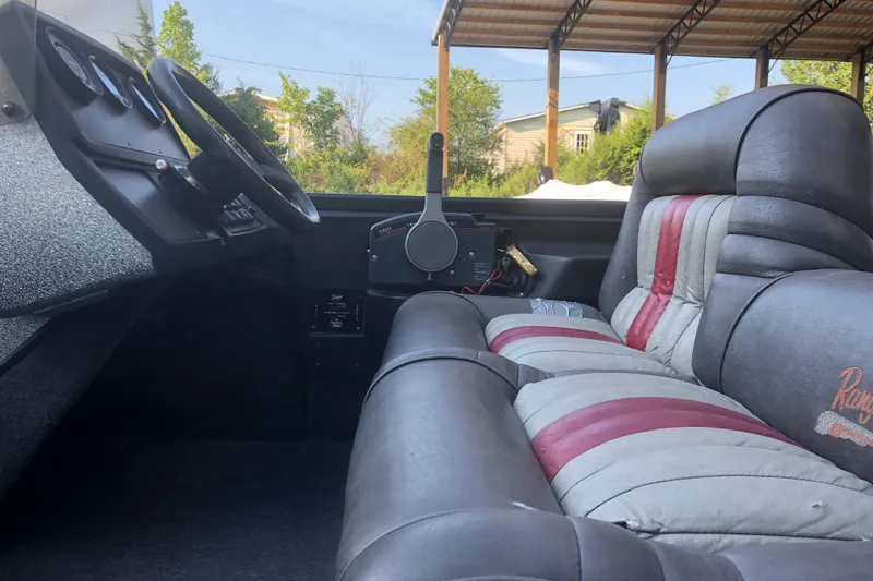 Slide: The Image of 1993 Ranger Comanche 482v boat interior with gray and red seating, steering wheel, and dashboard. - 14