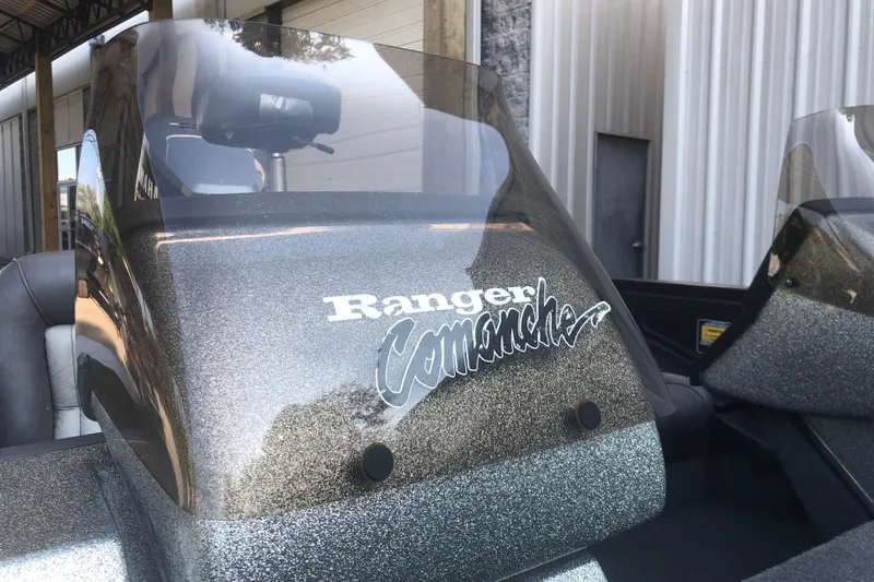 Slide: The Image of 1993 Ranger Comanche 482v boat with windshield and logo, parked near a building. - 9