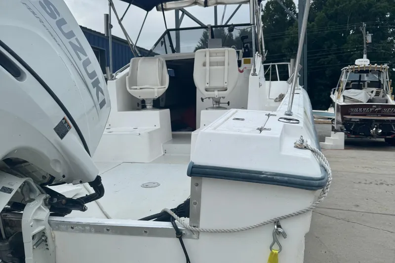Slide: The Image of 1993 Angler 22 Walk Around boat with Suzuki outboard motor, docked outdoors. - 3