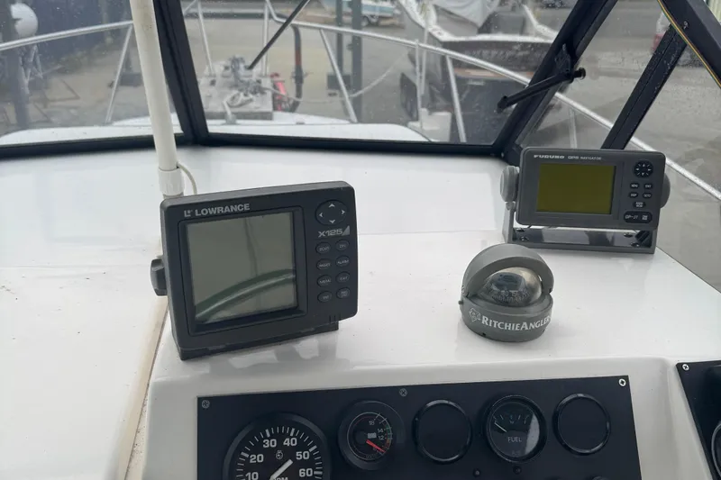 Slide: The Image of 1993 Angler 22 Walk Around boat dashboard with navigation equipment and compass. - 7
