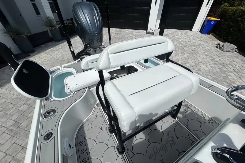 Slide: The Image of 2016 Yellowfin 24 Bay boat with white seating and open storage compartments. - 14