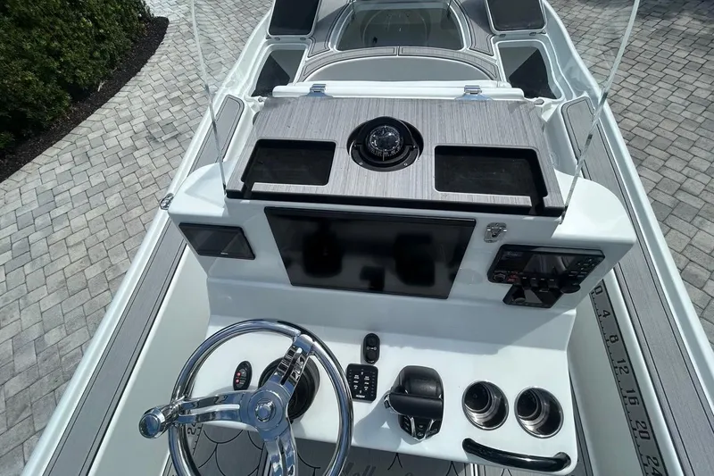Slide: The Image of 2016 Yellowfin 24 Bay boat dashboard with steering wheel and navigation controls. - 16