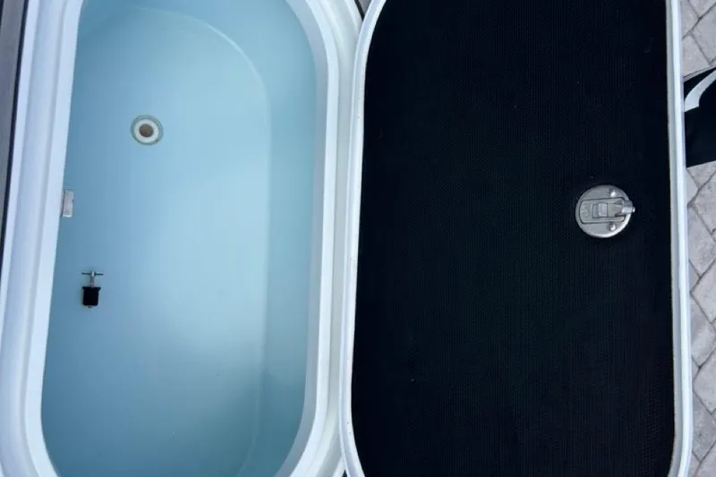 Slide: The Image of Open storage compartment on a 2016 Yellowfin 24 Bay boat, showing interior and closed lid. - 18