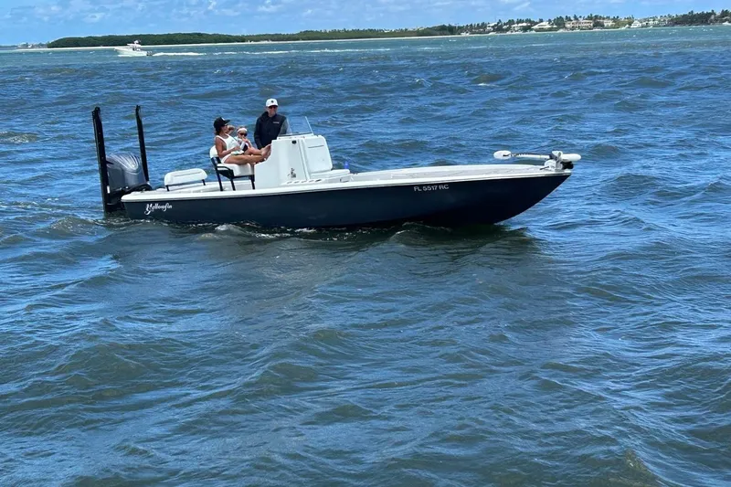 Slide: The Image of 2016 Yellowfin 24 Bay boat cruising on open water with passengers onboard. - 2