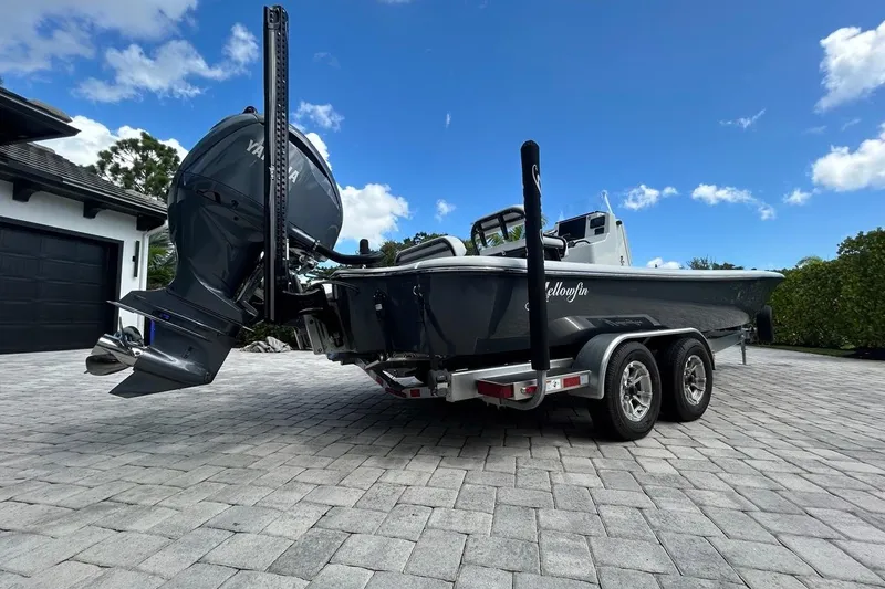 Slide: The Image of 2016 Yellowfin 24 Bay boat on trailer, parked on paved driveway under blue sky. - 33