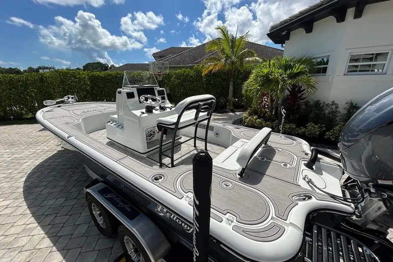 Slide: The Image of 2016 Yellowfin 24 Bay boat parked on a driveway, surrounded by lush greenery. - 37