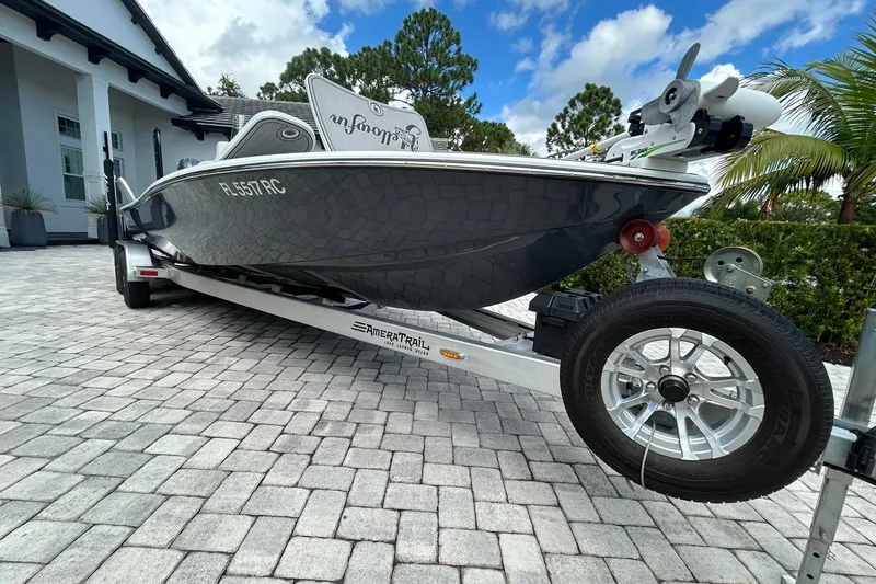 Slide: The Image of 2016 Yellowfin 24 Bay boat on trailer, parked on paved driveway, under blue sky. - 39