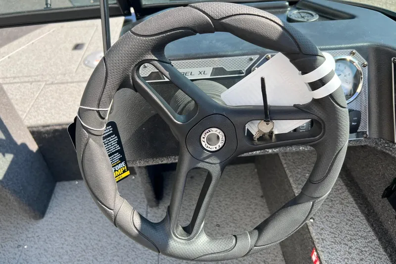 Slide: The Image of Steering wheel of 2026 Lund 1650 Rebel XL Sport boat with keys attached. - 11