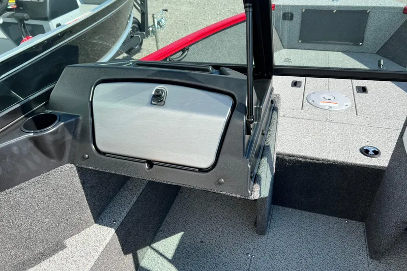 Slide: The Image of 2026 Lund 1650 Rebel XL Sport boat interior with storage compartment and cup holder. - 13