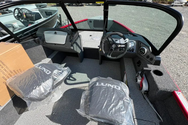 Slide: The Image of 2026 Lund 1650 Rebel XL Sport boat interior with steering wheel and covered seats. - 14