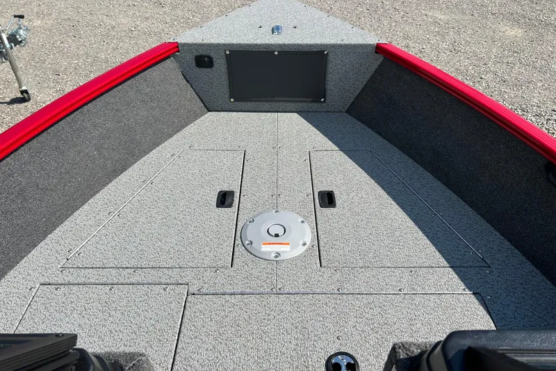 Slide: The Image of 2026 Lund 1650 Rebel XL Sport boat interior with gray carpet and red trim. - 15