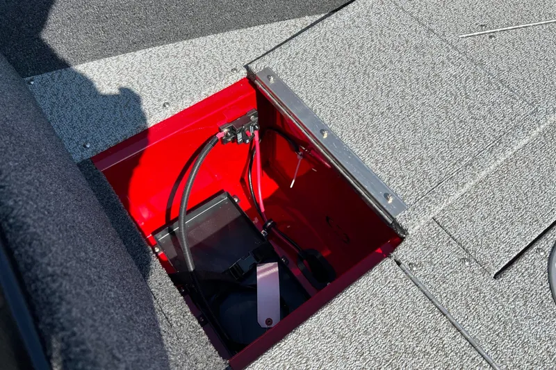 Slide: The Image of 2026 Lund 1650 Rebel XL Sport boat battery compartment with red interior and wiring. - 17