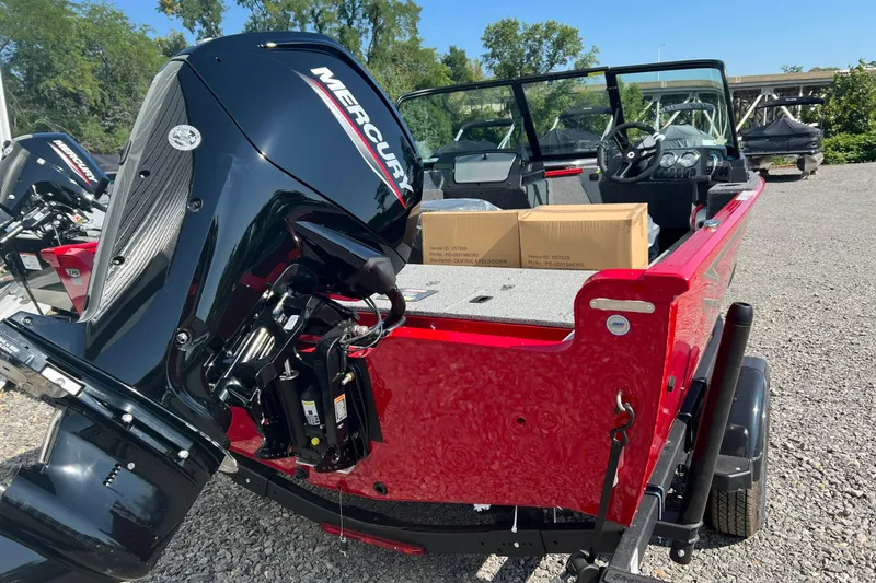 Slide: The Image of 2026 Lund 1650 Rebel XL Sport boat with Mercury engine, parked on gravel. - 5
