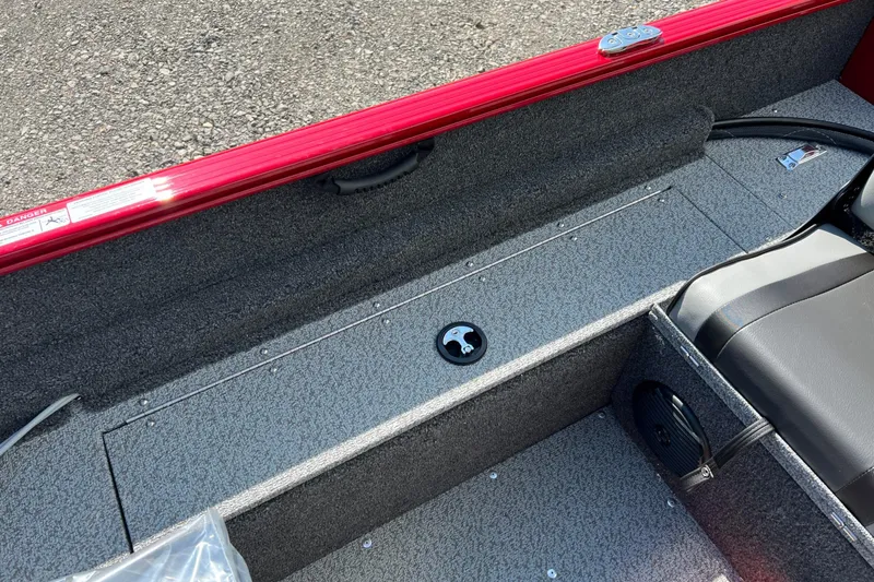 Slide: The Image of 2026 Lund 1650 Rebel XL Sport boat interior with red trim and gray flooring. - 8