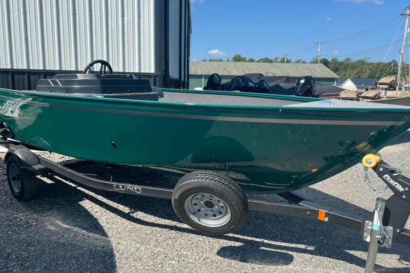The Image of 2026 Lund 1650 Angler SS boat on trailer, green exterior, parked outdoors. - 1