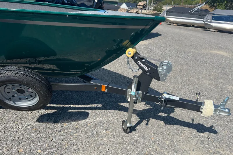 Slide: The Image of 2026 Lund 1650 Angler SS boat on trailer, parked on gravel surface. - 5