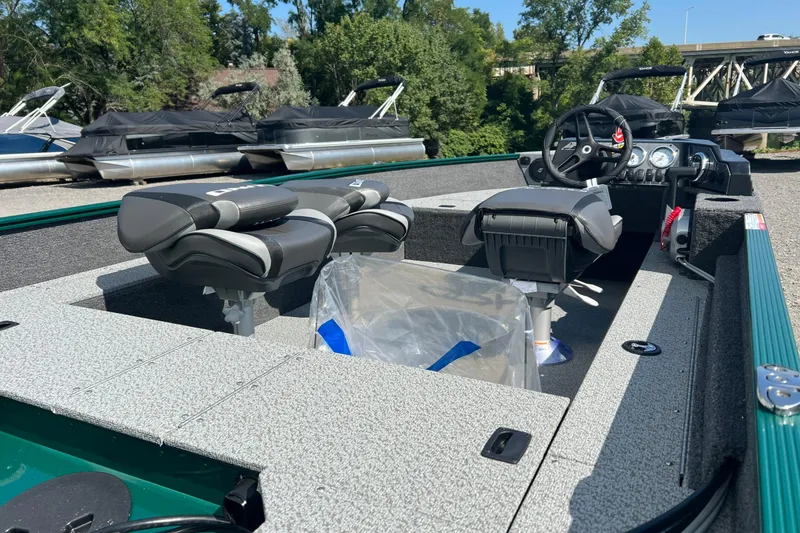 Slide: The Image of 2026 Lund 1650 Angler SS boat interior with seating and steering wheel, docked outdoors. - 7