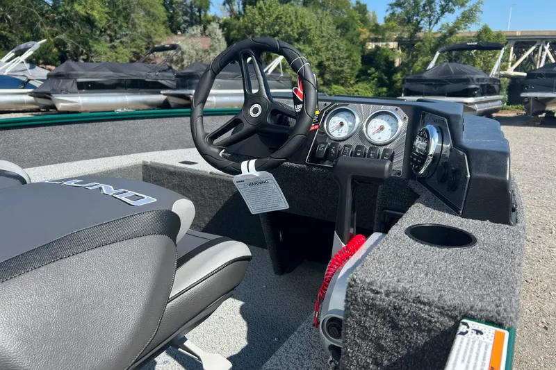 Slide: The Image of 2026 Lund 1650 Angler SS boat interior with steering wheel and dashboard controls. - 8