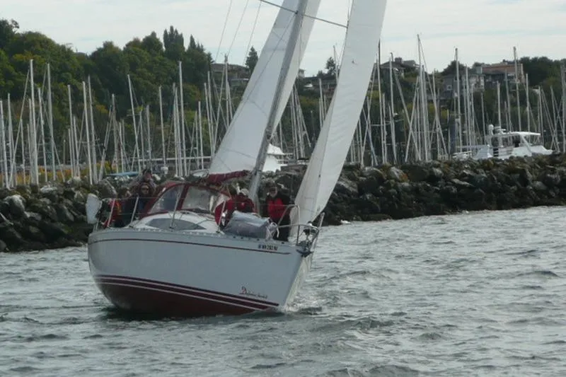 Slide: The Image of Sailing yacht Delphia 33 (2007) navigating near a marina with numerous sailboats. - 3