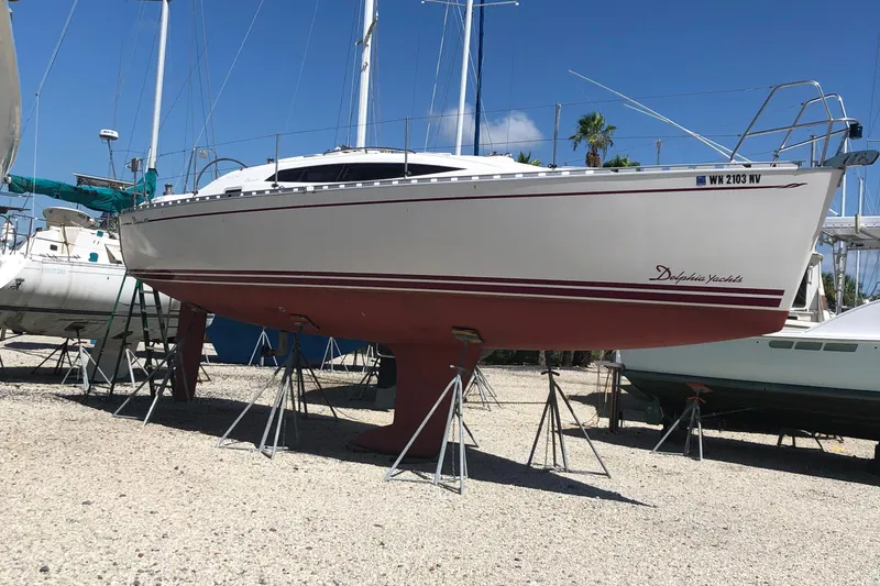 Slide: The Image of 2007 Delphia 33 sailboat on stands in a boatyard, clear sky background. - 5