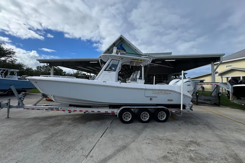 Slide: The Image of 2022 Everglades 295 Center Console boat on trailer, parked outdoors under cloudy sky. - 1