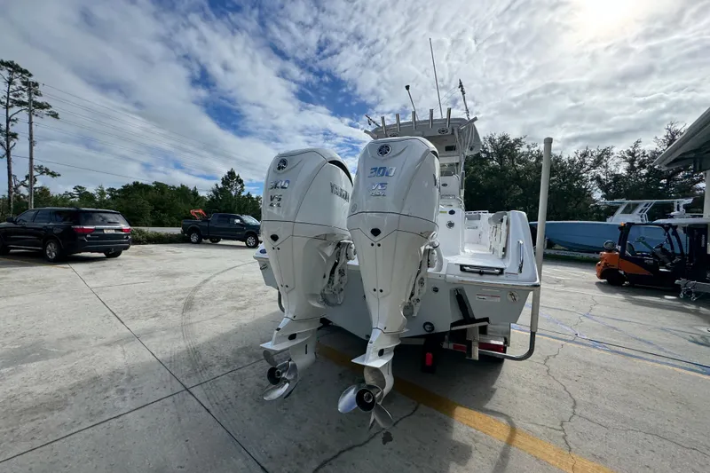 Slide: The Image of 2022 Everglades 295 Center Console boat with dual outboard engines in a parking lot. - 13