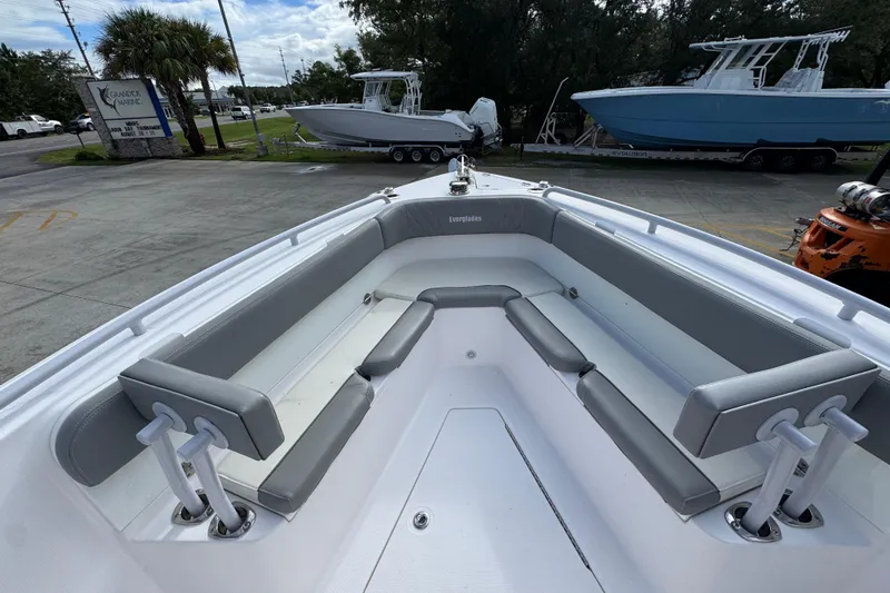 Slide: The Image of 2022 Everglades 295 Center Console boat with spacious seating area, parked outdoors. - 19