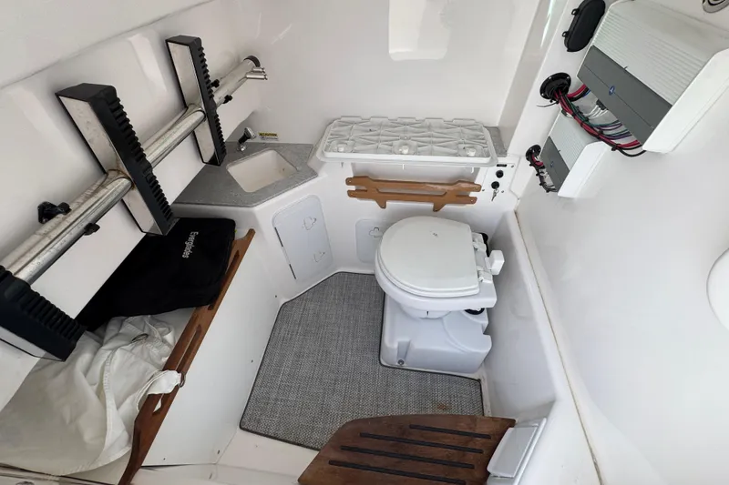 Slide: The Image of 2022 Everglades 295 Center Console boat interior with toilet, sink, and storage. - 27