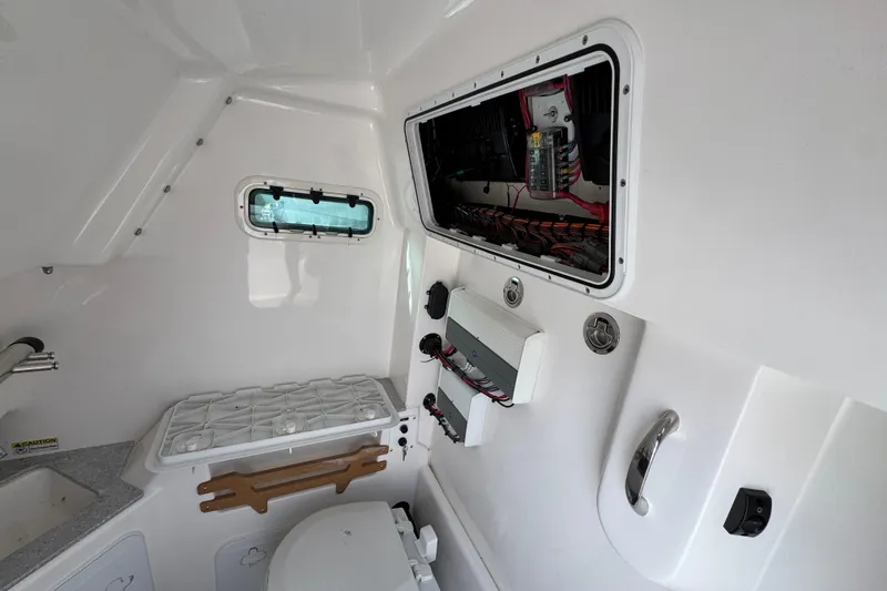 Slide: The Image of Interior of 2022 Everglades 295 Center Console boat, featuring electrical panel and compact amenities. - 28
