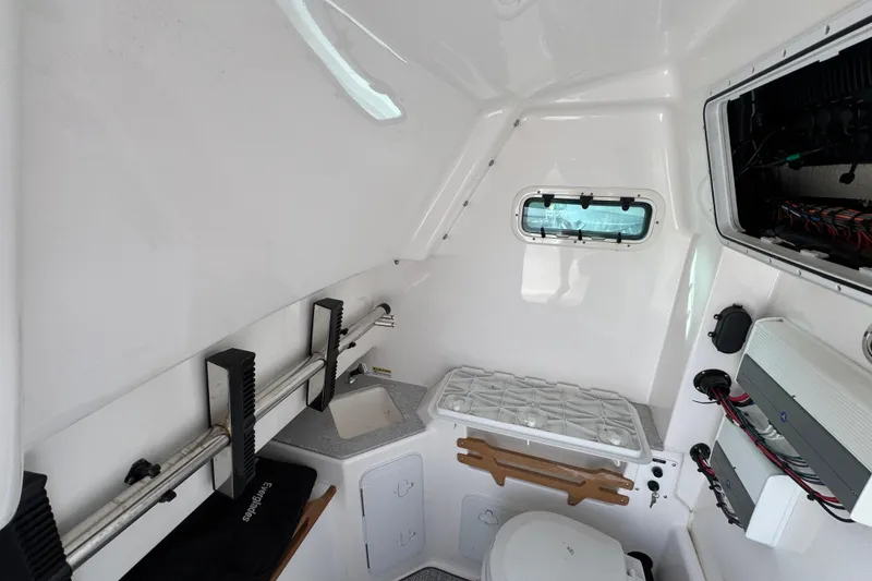 Slide: The Image of Interior of 2022 Everglades 295 Center Console boat, featuring compact bathroom and storage. - 29