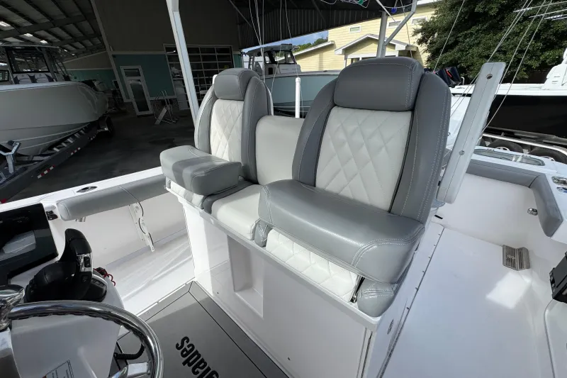 Slide: The Image of 2022 Everglades 295 Center Console boat with luxurious seating in a marina setting. - 30