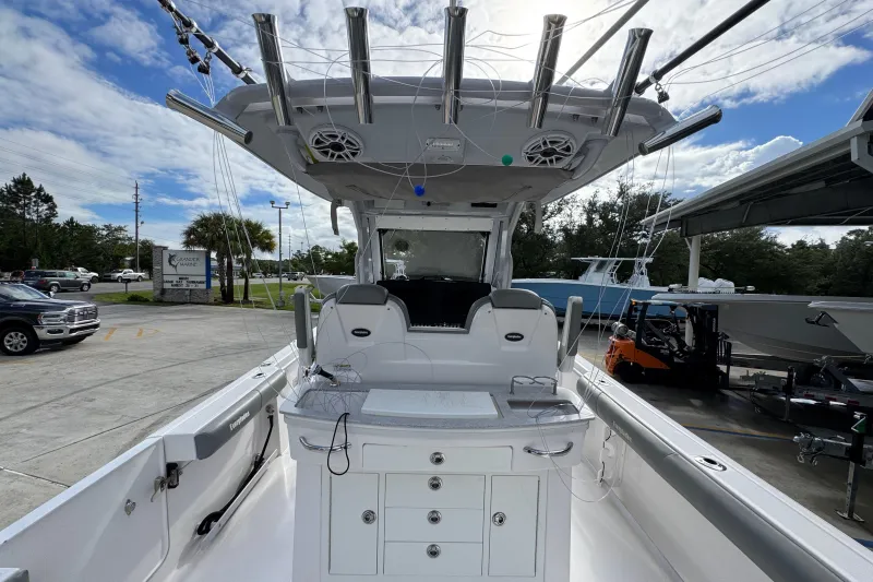 Slide: The Image of 2022 Everglades 295 Center Console boat with fishing rod holders and storage, docked outdoors. - 36