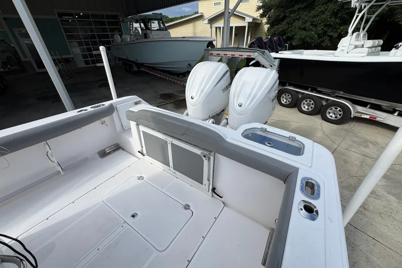 Slide: The Image of 2022 Everglades 295 Center Console boat with dual Yamaha outboard engines in a marina setting. - 38