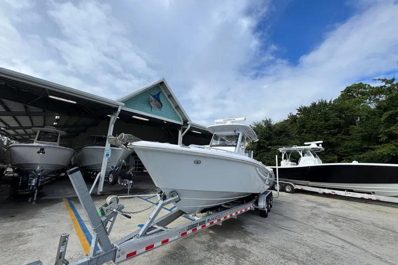 Slide: The Image of 2022 Everglades 295 Center Console boat on trailer at marina under cloudy sky. - 4