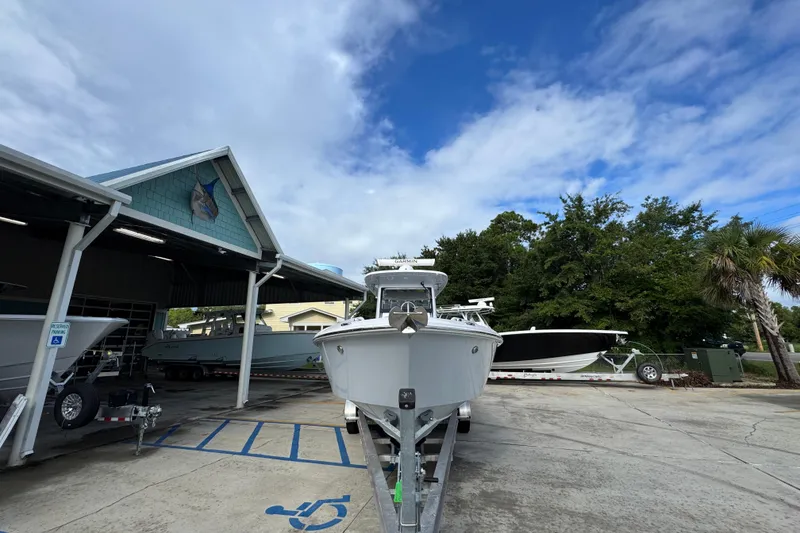 Slide: The Image of 2022 Everglades 295 Center Console boat on trailer at marina under blue sky. - 6