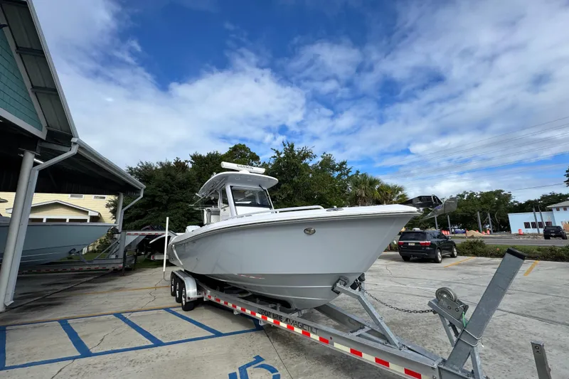 Slide: The Image of 2022 Everglades 295 Center Console boat on trailer, parked outdoors under blue sky. - 7