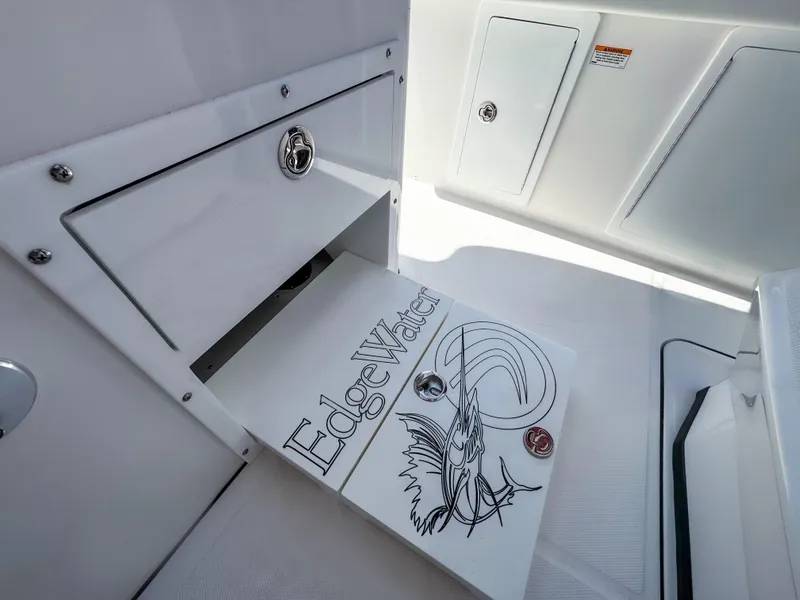 Slide: The Image of 2025 Edgewater 370CC boat interior with branded storage compartment and sleek design. - 19
