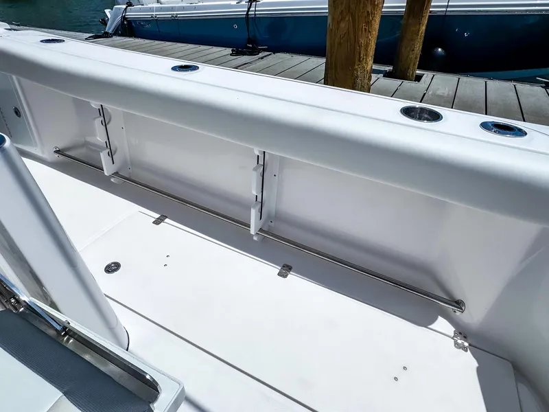 Slide: The Image of 2025 Edgewater 370CC boat deck with rod holders and storage compartments. - 31