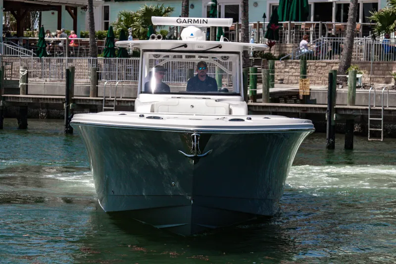 Slide: The Image of 2025 Edgewater 370CC boat navigating a marina, featuring Garmin equipment. - 3