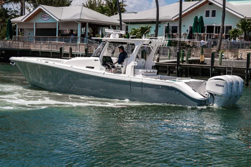 Slide: The Image of 2025 Edgewater 370CC boat cruising near a marina with Yamaha engines. - 9