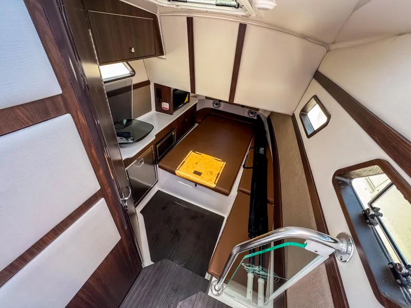 Slide: The Image of Interior of 2025 Edgewater 370CC boat, featuring modern kitchen and cozy seating area. - 21