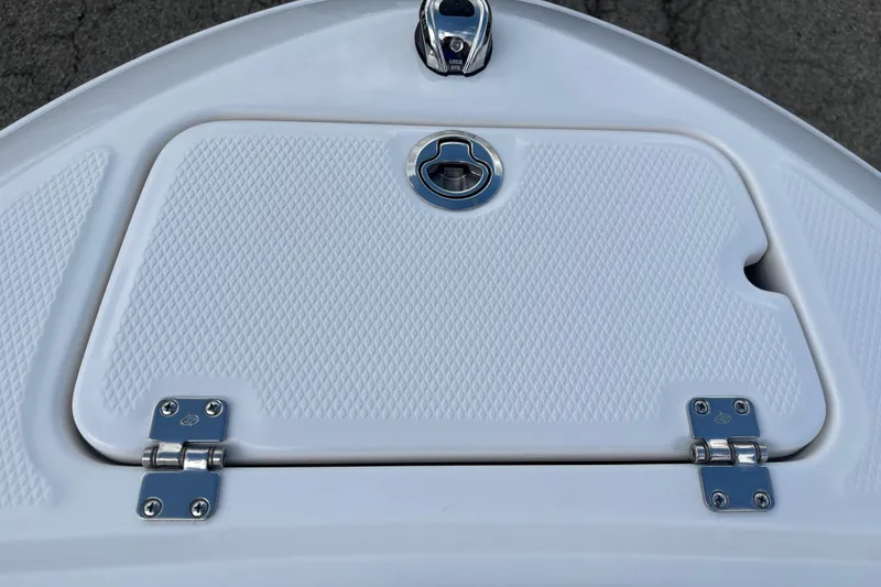 Slide: The Image of 2026 Chaparral 21 SSi boat hatch with textured surface and metal hinges. - 10