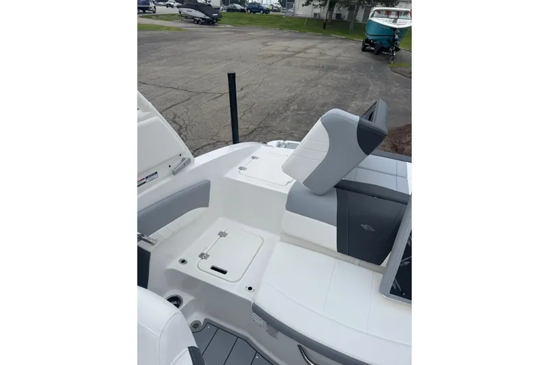 Slide: The Image of 2026 Chaparral 21 SSi boat interior with gray and white seating, docked outdoors. - 22